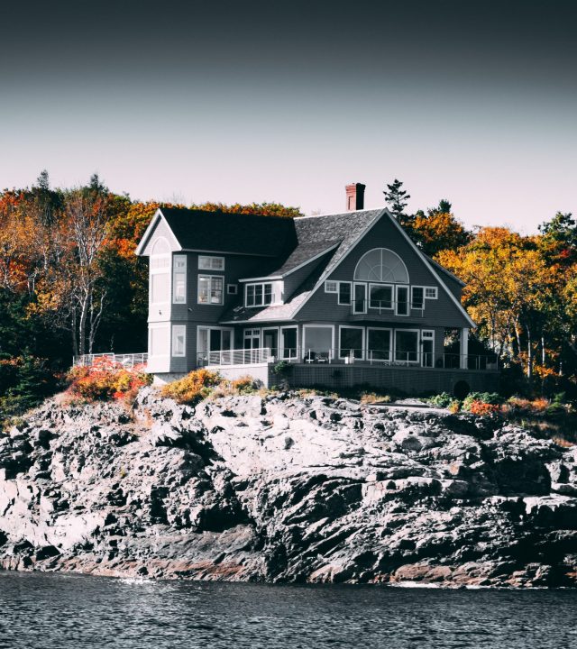 House by rocks on lake